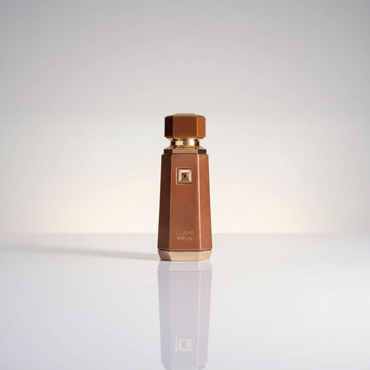Fragrance World Liquid Brun Eau de Parfum Flakon in Braun mit goldener Kappe und Spiegelung.