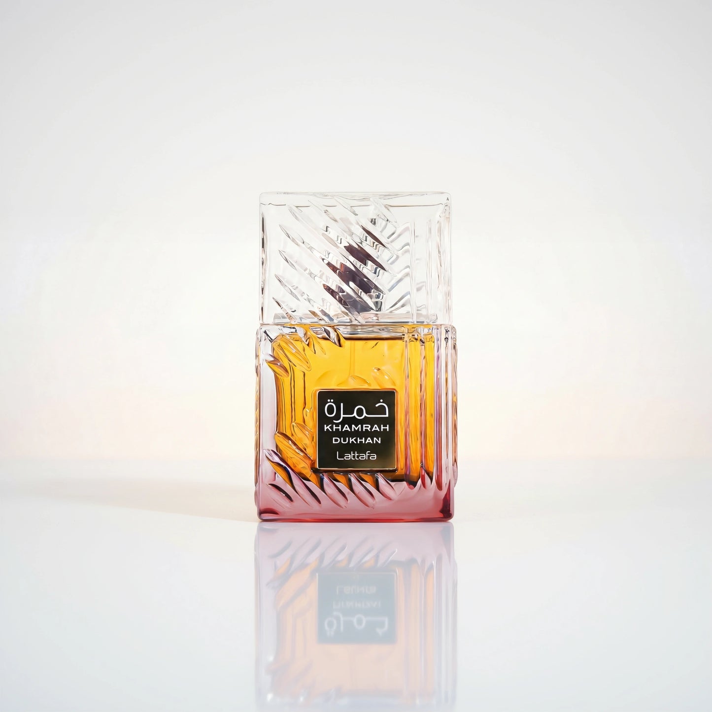 Lattafa Khamrah Dukhan Eau de Parfum Flakon aus geschliffenem Glas mit bernsteinfarbener Flüssigkeit und Spiegelung.
