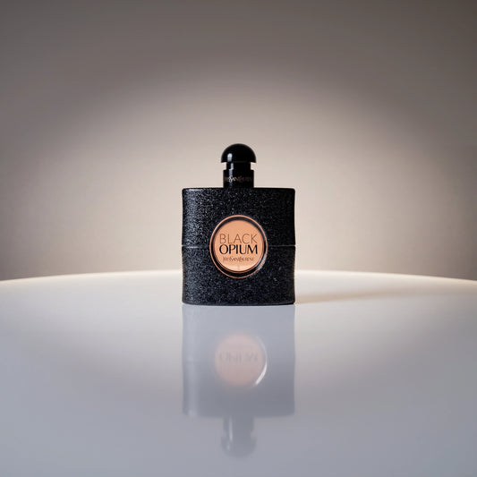 Yves Saint Laurent Black Opium Eau de Parfum Flakon mit eleganter Spiegelung auf hellem Untergrund.