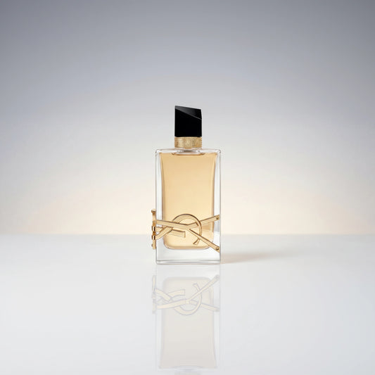 Eleganter Flakon des Yves Saint Laurent Libre Eau de Parfum mit goldener Logo-Verzierung und Spiegelung auf hellem Untergrund.